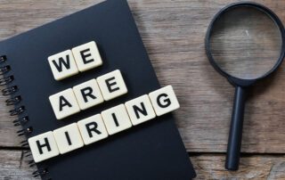 'We are hiring' letters and magnifying glass